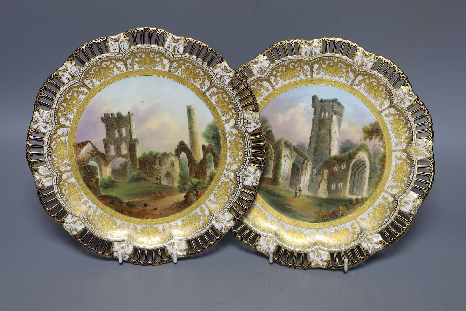 A pair of Coalport pierced border plates painted with named ruins scenes Ruins of Cathedral Kildare and Melrose Abbey mark Coalport AD 1750 in blue 23.5cm